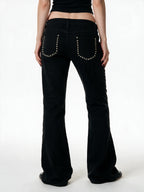 Black low rise flare jeans with a studded waistband