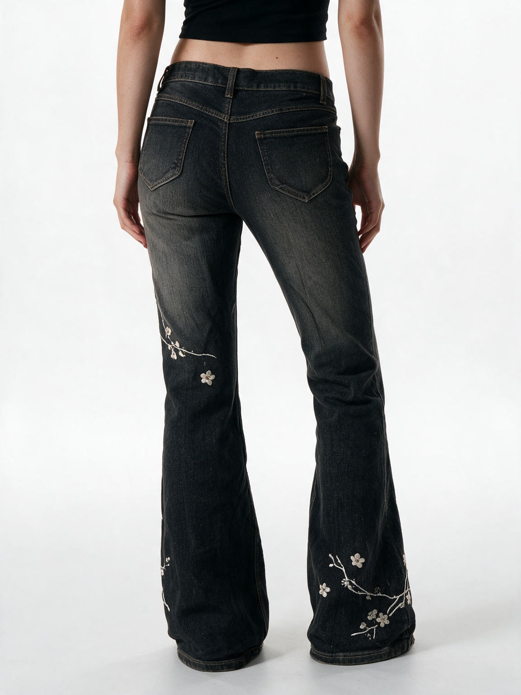 Washed black flare jeans with pale floral embroidery