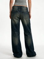 Distressed dark blue jeans with rivet patches