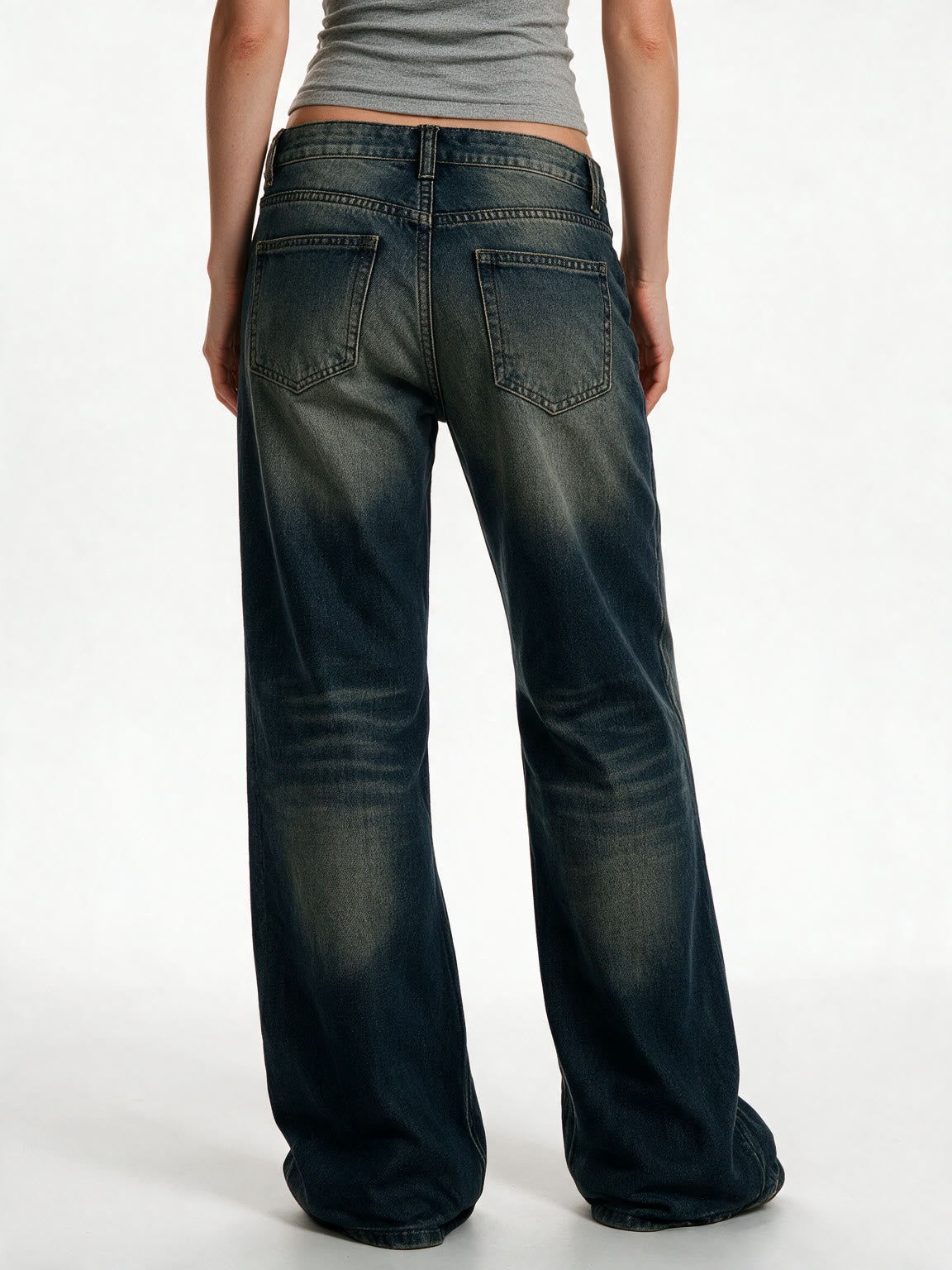 Distressed dark blue jeans with rivet patches