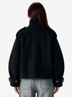 Cropped black wool jacket with buckled cuffs and a high collar
