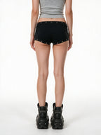 Black micro shorts with grommets and a gold cross