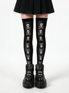 Black thigh high socks printed with white skulls and crossbones