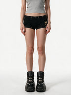 Black micro shorts with grommets and a gold cross