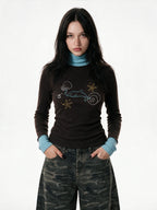 Brown turtleneck long sleeve top with pale blue cuffs