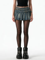 Washed denim pleated mini skirt with a riveted belt