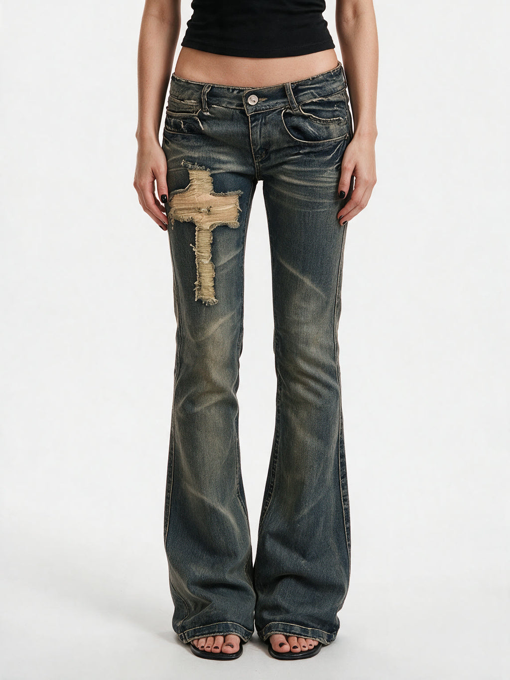 Washed blue flare jeans with a cross patch on the leg