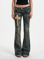 Washed blue flare jeans with a cross patch on the leg