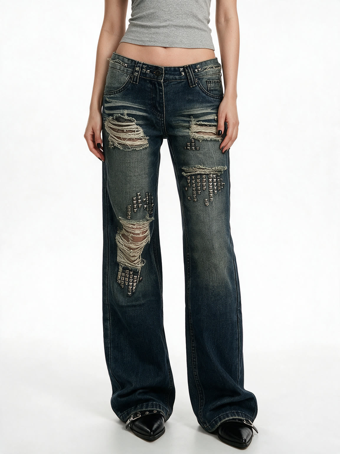 Distressed dark blue jeans with rivet patches
