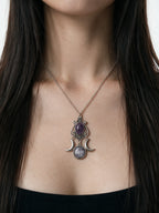 Silver crescent moon necklace with a purple amethyst stone