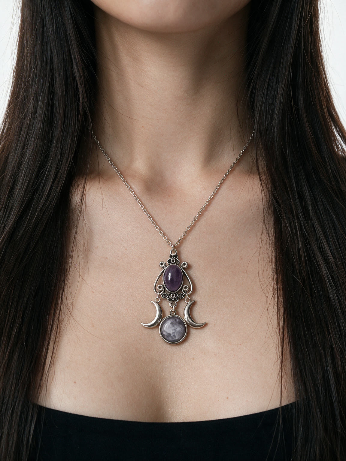 Silver crescent moon necklace with a purple amethyst stone