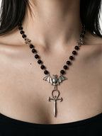 Black bead rosary necklace with a bat and dagger pendant