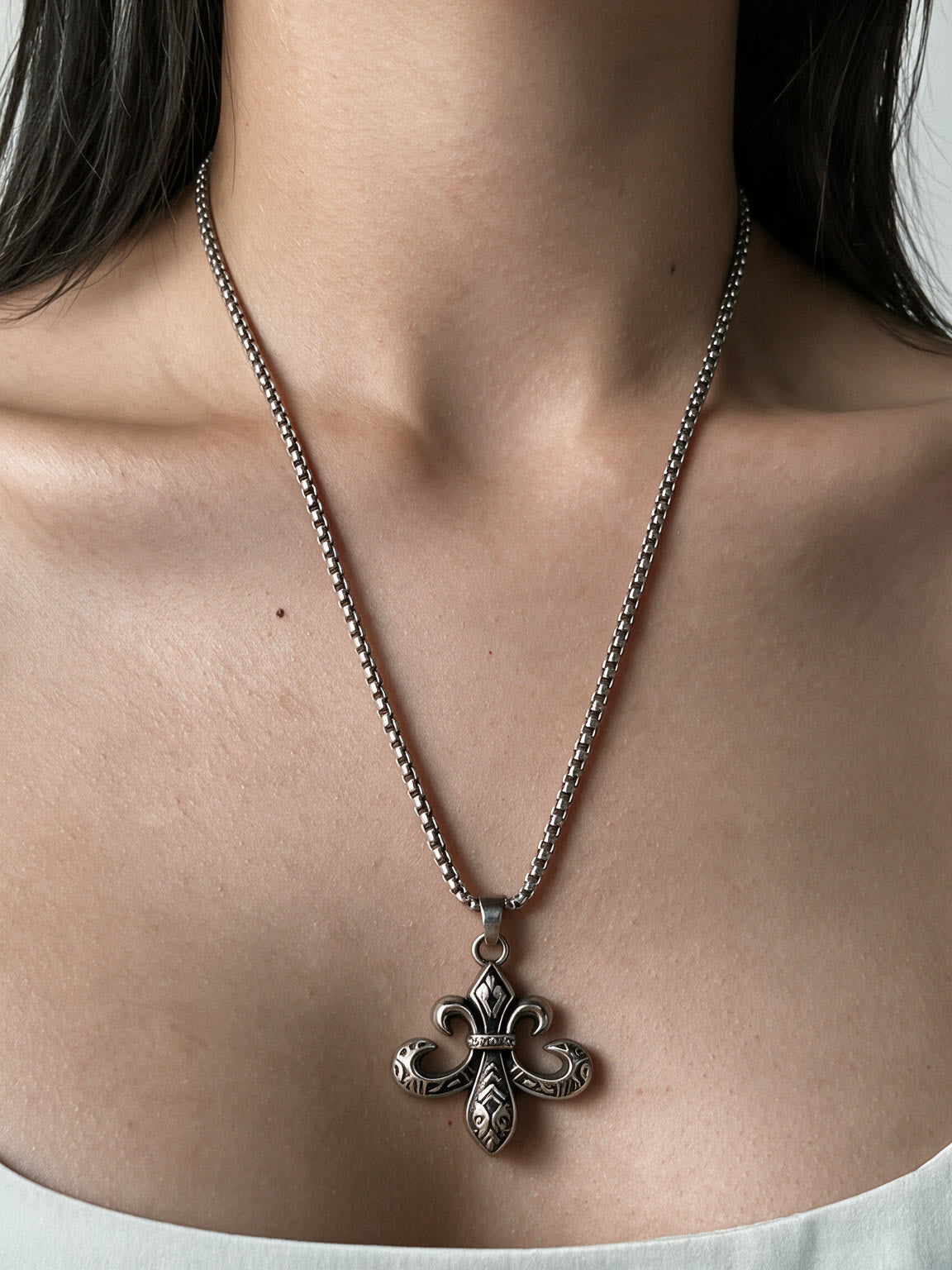 Ornate silver baroque cross pendant on a long chain
