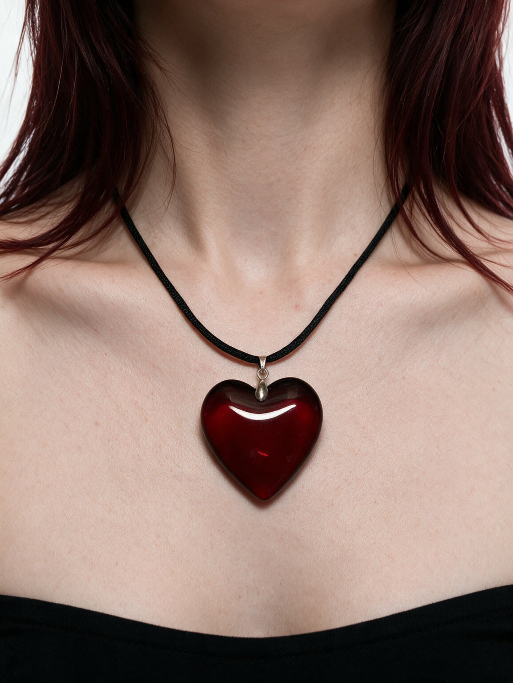 Red glass heart pendant on a black cord necklace