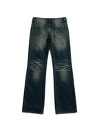 Distressed dark blue jeans with rivet patches