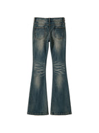 Washed blue flare jeans with a cross patch on the leg