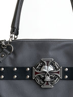 Grey studded moto bag with a silver cross emblem