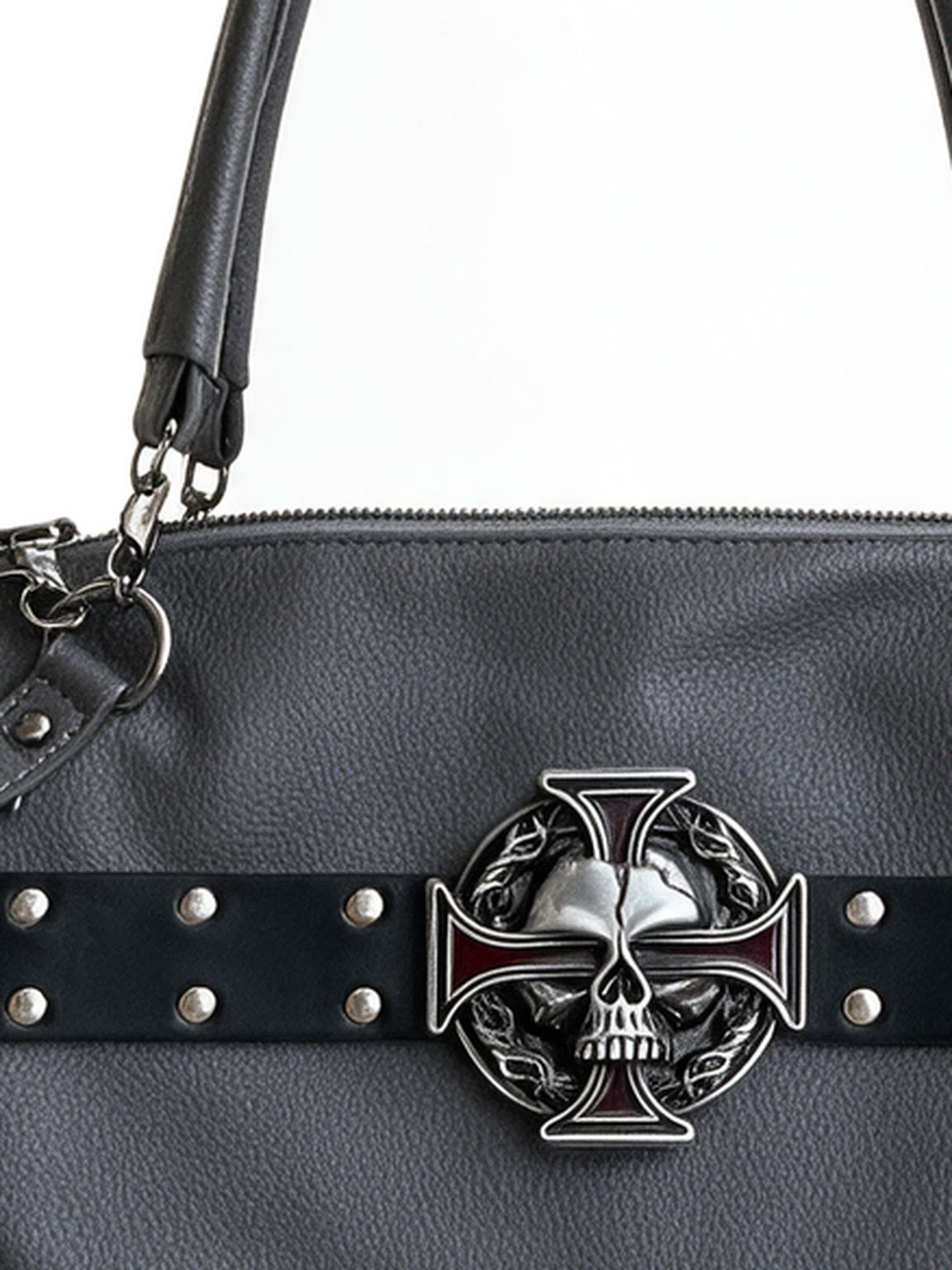 Grey studded moto bag with a silver cross emblem