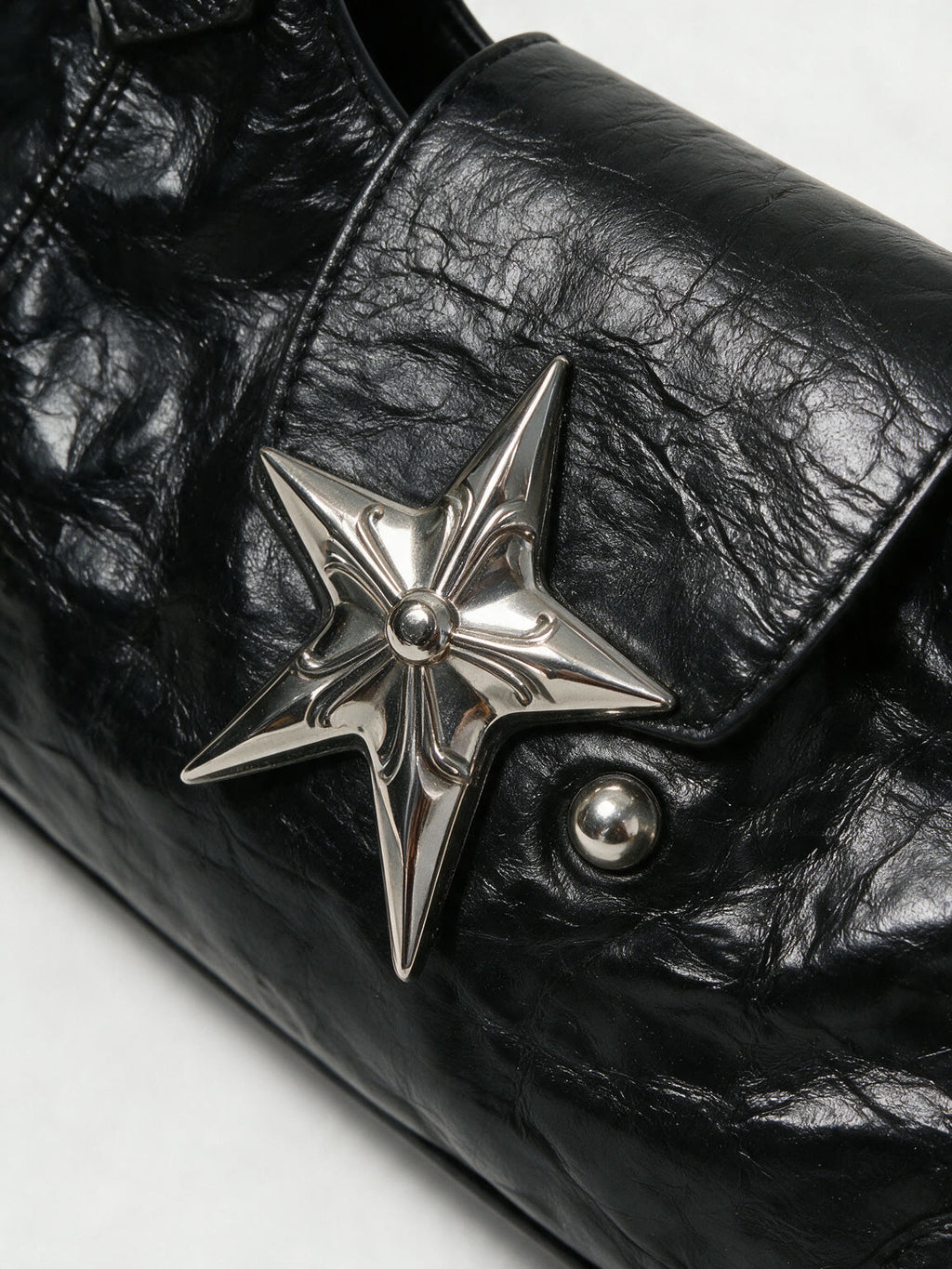 Black leather baguette bag with a large silver star and studs