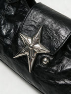 Black leather baguette bag with a large silver star and studs