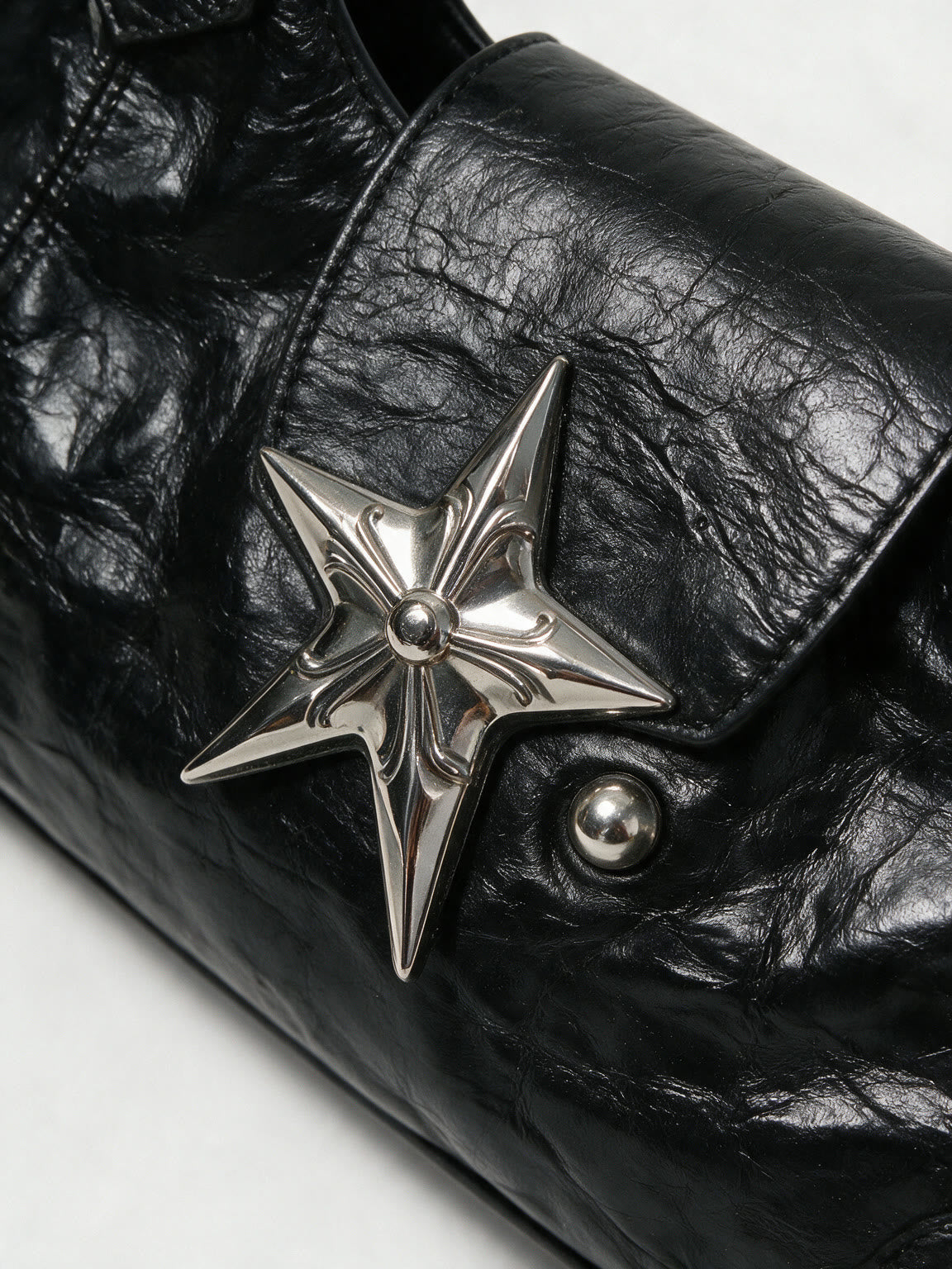Black leather baguette bag with a large silver star and studs