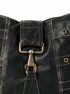 Black leather shoulder bag with multiple buckled straps and a padlock charm