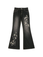 Washed black flare jeans with pale floral embroidery