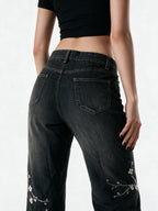 Washed black flare jeans with pale floral embroidery